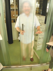 7階で場所を確認する光島さん